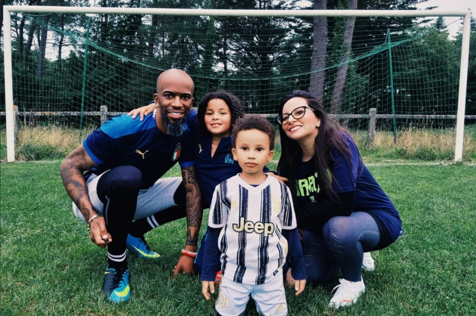 Claudia, Jerome and their two children together in front of a football goal.